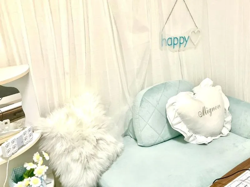 ミント色のソファと白いクッションのあるブース